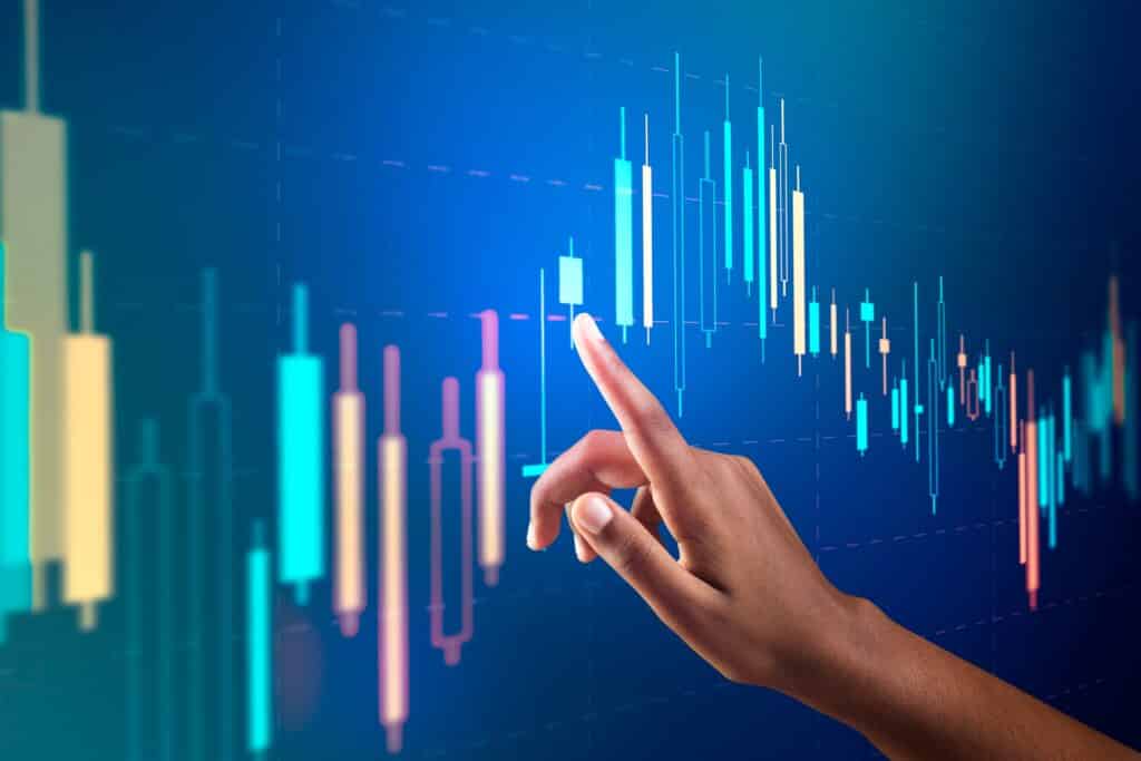 Ilustração com gráficos financeiros em tela de computador, representando análise técnica e escolha de softwares de trading.